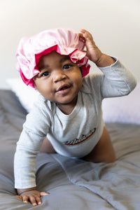 Baby playing with bonnet